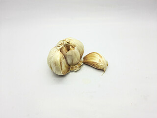 Fresh garlic bulb and clove on a white surface ready for cooking preparation