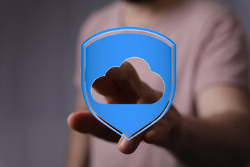 A person extending a hand holding a blue cloud computing symbol, representing safe data storage and...