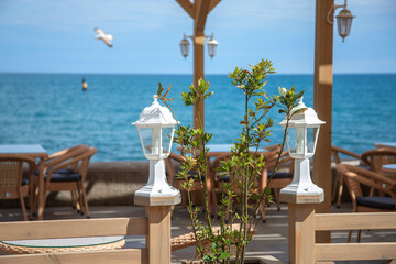 White street lamps enclose the cafe's summer terrace. The restaurant's beautiful design by the seaside.