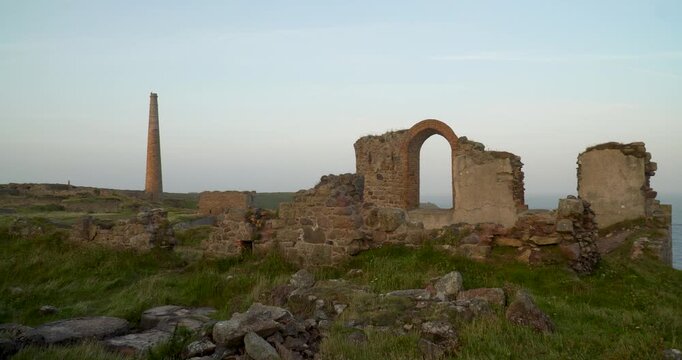 Old stone ruins of engine houses at Botallack mines on the Atlantic coast of Cornwall, England, UK during golden hour at sunrise