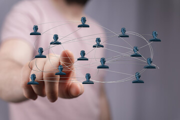 Close-up of a finger touching connected people icons representing a network, teamwork, and digital connectivity, representing global communicati
