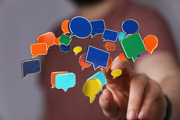 Hand reaching out to connected speech bubbles, concept of communication, social media, and digital networking.