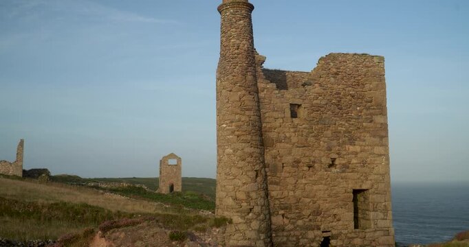 Old stone ruins of engine houses at Botallack mines on the Atlantic coast of Cornwall, England, UK during golden hour at sunrise
