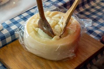 Queijo em t&aacute;bua derretido, com colher