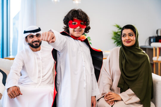 Arab family son playing superhero at home