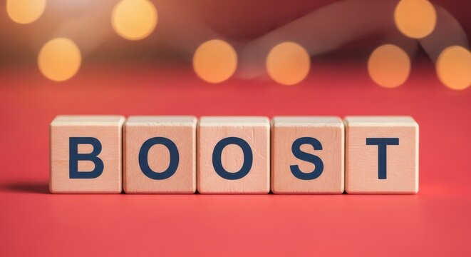 Wooden blocks spelling BOOST concept for motivation and improvement on a red background with bokeh lights