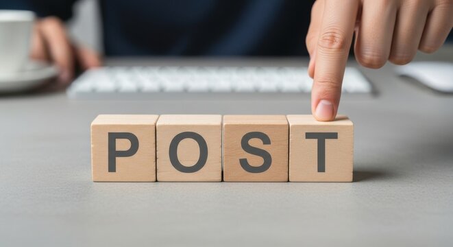 Wooden blocks spelling the word POST a finger pointing at the T concept for social media and online communication
