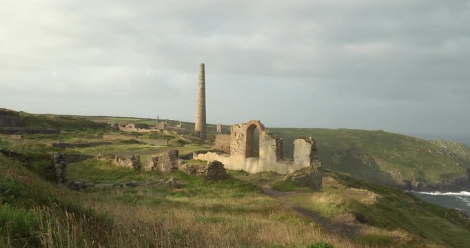 Old stone ruins of engine houses at Botallack mines on the Atlantic coast of Cornwall, England, UK during golden hour at sunrise