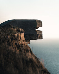 Bunker structure overlooking the ocean at sunset near coastal cliffs in France