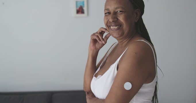 African senior woman with diabetes patch - Lifestyle and people diseases concept