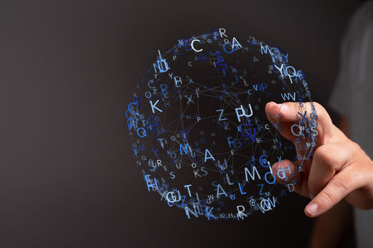 A futuristic image of a hand interacting with a digital sphere composed of letters and lines, representing conc