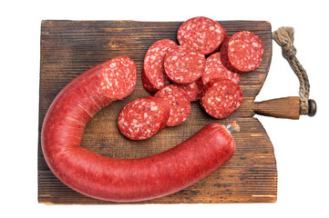 Whole and sliced Turkish sucuk (sujuk) on a rustic cutting board. Traditional spicy dry-cured sausage.