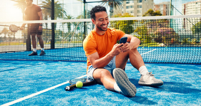 Fitness, texting and man on tennis court with phone, match schedule and social media update on rest. Padel, smile and athlete outdoor with tech, wellness chat and virtual tutorial on training break.