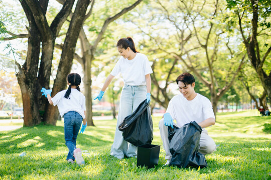 Joyful family volunteering to clean up a green park together. A positive lifestyle scene promoting eco-awareness, teamwork, and love for nature.