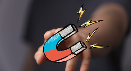 Hand holding a magnet, symbolizing attraction, leads, customers, marketing, success.