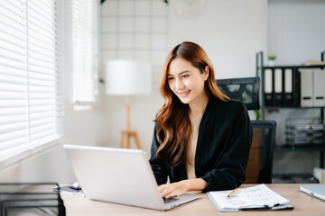 Business woman using tablet and laptop for doing math finance on an office desk, tax, report, accounting, statistics, and analytical research concept in office