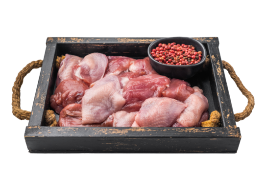 Raw quail breast fillets and pink peppercorns in a vintage black wooden crate. Fresh game meat for gourmet cooking.