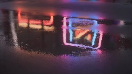 Neon Reflections in Puddle at Night.