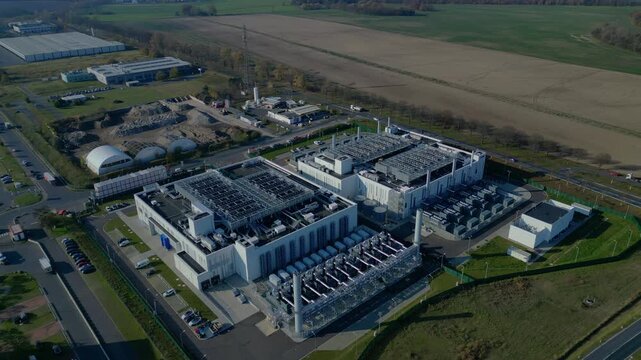 cutting edge technology and futuristic Ai infrastructure of a large-scale data center campus in Germany processing global information. Unique aerial view flight drone top down Above view