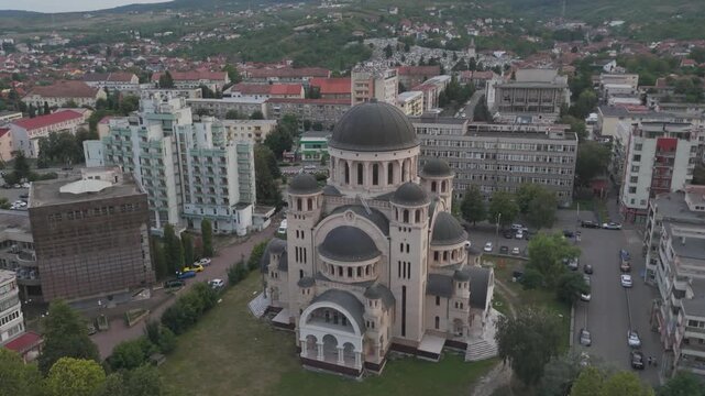 Aerial drone footage capturing Catedrala Adormirea Maicii Domnului in Deva, highlighting its multiple cupolas and surrounding urban landscape.