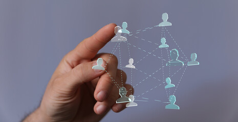 Hand holding digital network of people, representing connection, communication, and teamwork in...