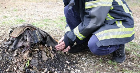 A video of a firefighter in uniform expertly and safely building a campfire in a controlled outdoor setting. This compelling footage demonstrates skill and knowledge, suitable for safety training.