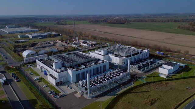 cutting edge technology and futuristic Ai infrastructure of a large-scale data center campus in Germany processing global information. Majestic aerial view flight panorama overview hovering drone