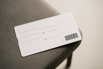 Blank airline ticket mockup on gray fabric chair in minimal setting for branding or travel concept presentation and clean design layout display. Ai generative