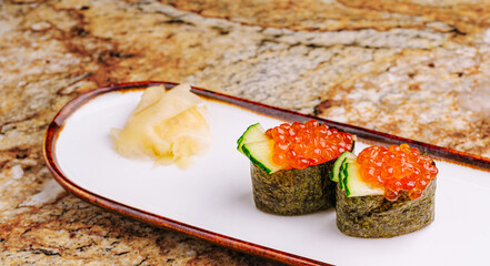 Delicious sushi rolls topped with fish roe and garnished with ginger