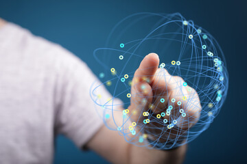 Abstract image of a hand interacting with a digital sphere representing technology, global connectivity, and data transfer. Concepts of innovati