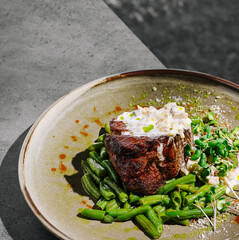 Delicious steak dish with green beans and creamy sauce served outdoors
