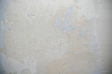 Textured wall surface showing peeling paint and plaster