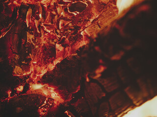 Direct view into fireplace focused on glowing embers, charred log on right with matte surface for text space, subtle warm tones, rustic cozy atmosphere, fire details emphasized.