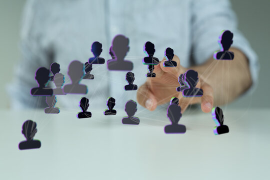 Abstract image showing interconnected network of people icons with a human hand pointing towards the center, co