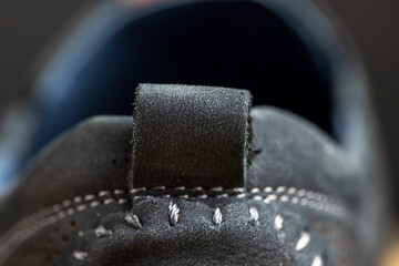 part of the shoe tongue for easy putting on, details of leather shoes close up