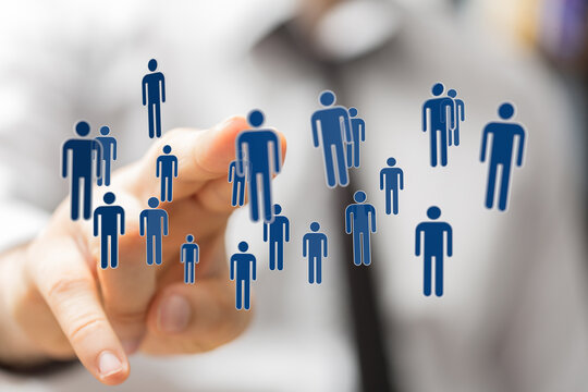 Concept of teamwork, community, and social networking with digital human icons hovering near finger.  Connected