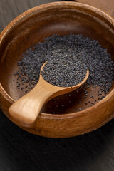 wooden bowl used in the manufacture of confectionery, a large amount of poppy seeds in a wooden bowl with a spoon