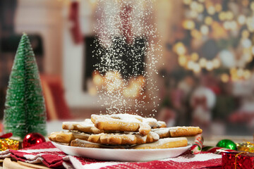 Christmas cookies sprinkled with powdered sugar on festive table