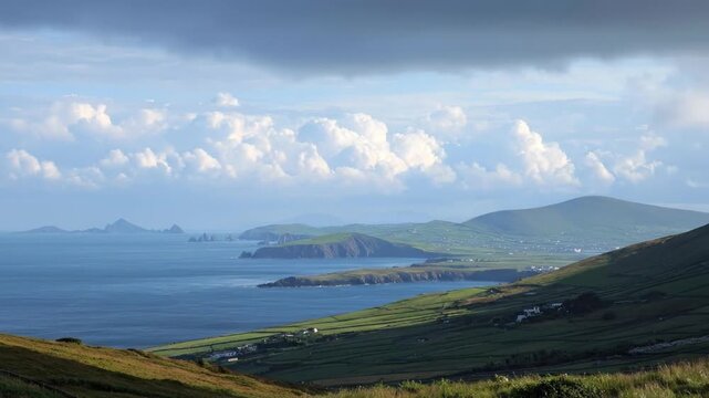 An expansive panoramic vista reveals a breathtaking coastal landscape under a dynamic sky. Rolling green hills, intricately textured with ancient field divisions, gently descend towards the serene dee