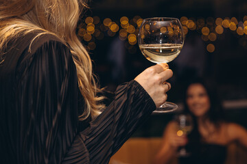 Woman holding wine glass at night celebration party