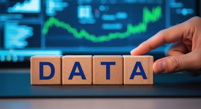 Wooden blocks spelling DATA hand touching the blocks financial chart in the background showing business analytics