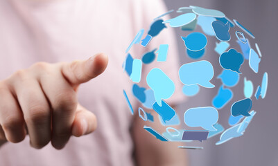 Person's hand pointing at abstract globe of speech bubbles, representing digital communication, social media, and global connection. Ideal for t