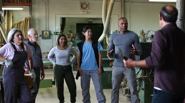 Diverse group of carpenters attending a team meeting in a workshop