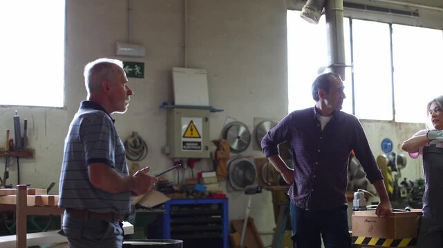 Mature instructor teaching a diverse carpentry class in a workshop