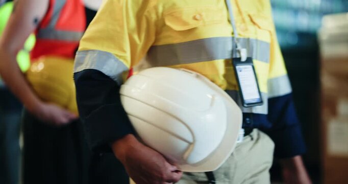 Hands, row and people walk with helmet for safety, warehouse inspection and industry protocol. Line, employees and waiting with hard hat for quality control, workplace compliance and construction ppe