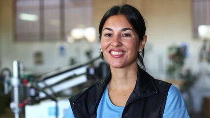 Confident female mechanic posing in a workshop