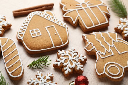 Tasty gingerbread cookies on light wooden table, closeup - Powered by Adobe