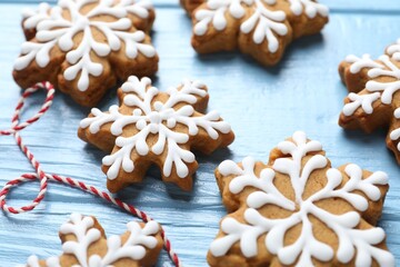 Tasty gingerbread cookies on light blue wooden background, closeup. Christmas treat