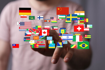 A hand reaching out to a network of international flags, symbolizing connection, global...