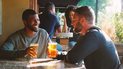 Two Male Friends Meeting In Bar Enjoying Drink Together
